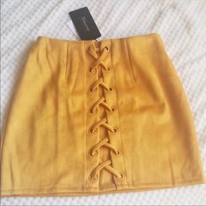 Mustard miniskirt with lace-up front. NWT